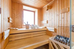 Habitación de madera con sauna y ventana en Almresort Gartnerkofel Nassfeld by ALPS RESORTS en Sonnenalpe Nassfeld