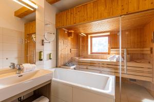 La salle de bains est pourvue d'une baignoire et d'un lavabo. dans l'établissement Almresort Gartnerkofel Nassfeld by ALPS RESORTS, à Sonnenalpe Nassfeld