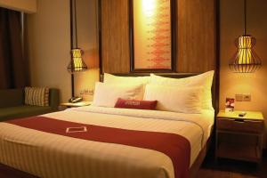Habitación de hotel con cama grande con almohadas blancas en Emersia Hotel & Resort Batusangkar en Batusangkar