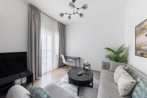 a living room with a couch and a table at Comfortable 2bd Apartment Next To Metro & Mall in Dubai