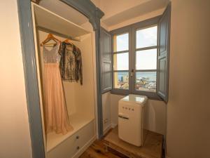 a dressing room with a gown hanging in a window at Palazzo Boyl 1840 in Cagliari