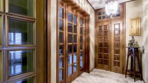 a walk in closet with wooden doors and a chandelier at Appartamento Stapane by Palazzo Stapane in Galatone +22 photos