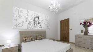 a bedroom with a bed and a painting on the wall at Appartamento Stapane by Palazzo Stapane in Galatone