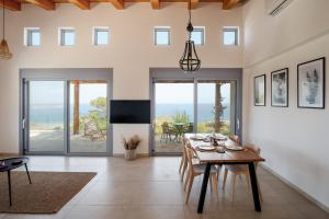 a dining room with a table and views of the ocean at Villa Thea in Mochlos