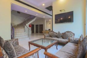 a living room with couches and a table and stairs at Hotel Blessings On road Near New Delhi Railway Station in New Delhi