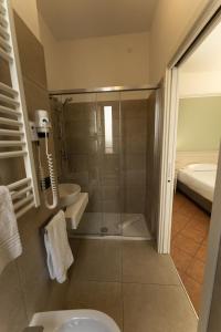 a bathroom with a shower and a toilet and a sink at Hotel Aquila in Castelfranco Emilia