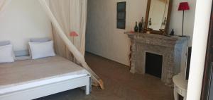 a room with a fireplace and a bed and a mirror at Cytyz Appart Hôtel in Mahajanga