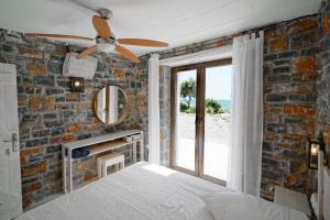 een slaapkamer met een bakstenen muur en een plafondventilator bij Magical Crete Villa| Villa Giorgos | Beautiful Sea & Landmark views | Terrace & Private Pool | 2 Bedrooms | Agia Galini in Agia Galini