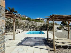 een zwembad met een houten pergola en stoelen bij Magical Crete Villa| Villa Giorgos | Beautiful Sea & Landmark views | Terrace & Private Pool | 2 Bedrooms | Agia Galini in Agia Galini