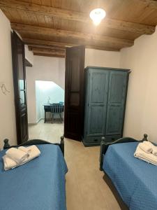 a bedroom with two beds and a room with a table at Casa Locci in San Vito