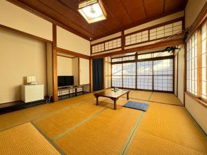 a large room with a table in a room with windows at Shiroyamasou in Asahi