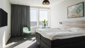 1 dormitorio con 1 cama grande, mesa y sillas en Comfort Hotel Skellefteå, en Skellefteå