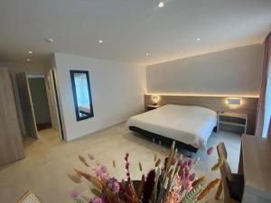 ein Hotelzimmer mit einem Bett und einem Tisch mit Blumen in der Unterkunft Hotel Louisa in Ostende