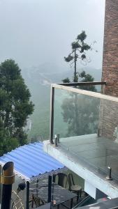 d'une table et de chaises sur un balcon avec vue. dans l'établissement Paradise Point Hotel & Restro, à Darjeeling