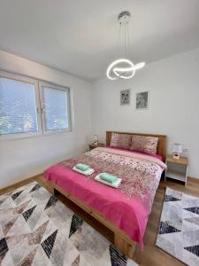 a bedroom with a large bed with a pink bedspread at R&D Central Apartment in Prilep