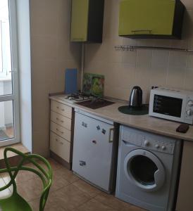 a kitchen with a washing machine and a microwave at Smart Apartment на Соборной 23 in Kremenchuk