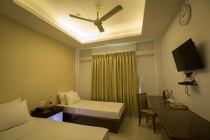 ein Hotelzimmer mit 2 Betten und einem Deckenventilator in der Unterkunft TANTRA BOUTIQUE HOTEL in Imphal