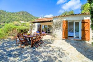 a patio with a table and chairs in front of a house at SELECT'SO HOME - Mas des Canadels - Services hôteliers & Prestations de qualité - RCMAS in Rayol-Canadel-sur-Mer