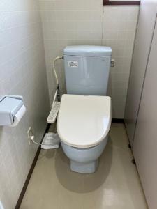 a bathroom with a white toilet in a stall at ビジネスホテルパークイン石巻 in Inai