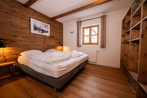 1 dormitorio con 1 cama en una habitación con paredes de madera en Chalet zur Rose, en Berwang