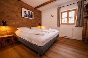 Cama grande en habitación con pared de madera en Chalet zur Rose, en Berwang