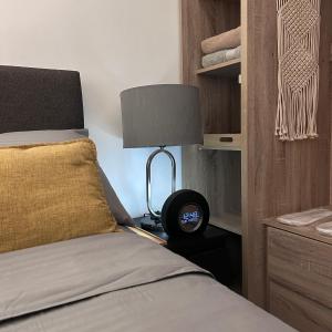 ein Schlafzimmer mit einem Bett mit einer Lampe daneben in der Unterkunft Evan Suite @ S Residences in Manila