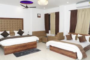 Habitación de hotel con 2 camas y sofá en Sun River Resort, en Dogadda