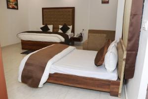 two beds in a hotel room withskirts at Sun River Resort in Dogadda
