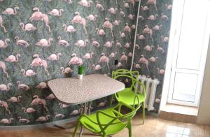 a table and chairs with a pink flamingos wallpaper at Smart Apartment на Соборной 23 in Kremenchuk