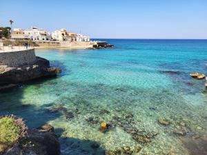 a beach with clear blue water and white buildings at Appartamento Stapane by Palazzo Stapane in Galatone