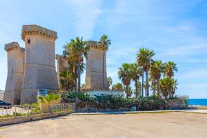 a building with towers with palm trees and the ocean at Appartamento Stapane by Palazzo Stapane in Galatone