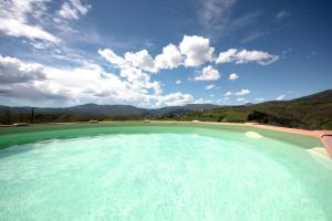 una grande piscina con cielo azzurro e montagne di Società Agricola Cacigolara a Borgo Val di Taro