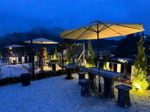 un gruppo di tavoli da picnic e ombrelloni di notte di Gold Crest Cameron Highlands a Tanah Rata
