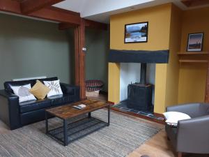 Lime Tree Hotel في فورت ويليام: غرفة معيشة مع أريكة ومدفأة