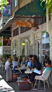 um grupo de pessoas sentadas em mesas fora de um restaurante em Modern Studio Retreat in Crown St with AirCon em Sydney