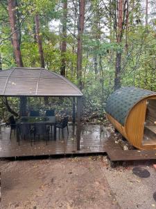 une terrasse en bois avec une table et un kiosque dans l'établissement Origami Chalet With open Air bath, à Hakuba