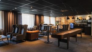 un bar con sillas, una mesa y un piano en Comfort Hotel Skellefteå, en Skellefteå
