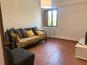 - un salon avec un canapé et des oreillers jaunes dans l'établissement Paradisa30 - Zona Ospedale Cisanello, à Pise