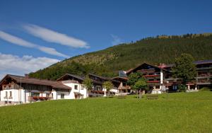 um edifício numa colina com um campo verde em LANIG Hotel Resort&Spa - Wellness und Feinschmeckerhotel - family owned and managed em Oberjoch