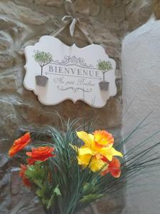 Un cartello su un muro con dei fiori sopra. di Vogesenparadies a Kirchberg