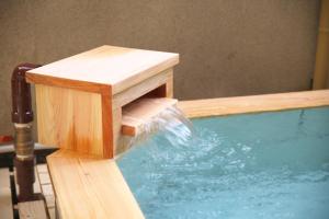 a swimming pool with a water fountain at Hanasuishou in Fuefuki