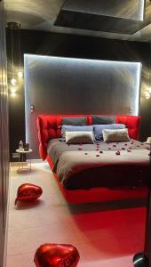 a bedroom with a red bed and red stools at Villa avec jacuzzi privatif in Saint-Cyr-lʼÉcole