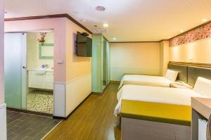 a hotel room with two beds and a bathroom at Dealer Hotel in Taipei