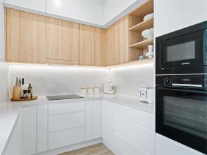 kuchnia z białymi szafkami i czarnym sprzętem AGD w obiekcie Peach at Palm View Collective w mieście Sydney +18 zdjęć