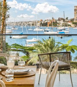 balkon ze stołem i krzesłami oraz widokiem na port w obiekcie Peach at Palm View Collective w mieście Sydney