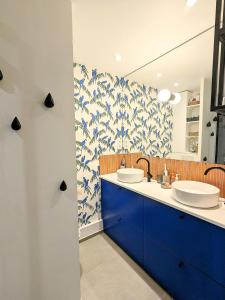 baño con 2 lavabos y papel pintado azul y blanco en Maison paisible Jardin & Jacuzzi à 500m de Paris, en Pantin