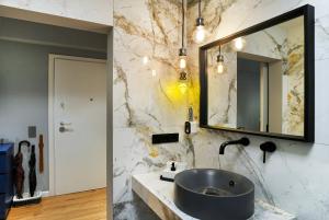 ein Bad mit einem Waschbecken und einem Spiegel in der Unterkunft Five Seasons Alimos in Athen