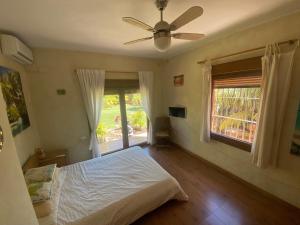 Un dormitorio con una cama y un ventilador de techo. en House near Conil with a Tropical Garden and Pool, en Conil de la Frontera 13 fotos más