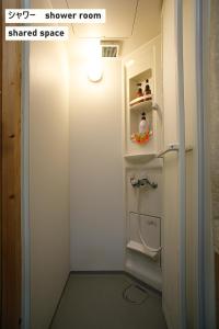 a small bathroom with a sink and a refrigerator at TAKIO Guesthouse - Vacation STAY 11604v in Higashi-osaka