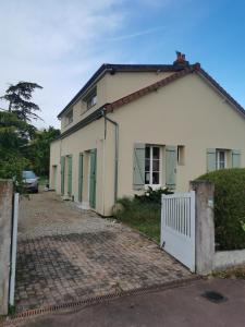 Casa blanca con puertas verdes y entrada en Bouvet Vincent, en Saint-Cyr-en-Val